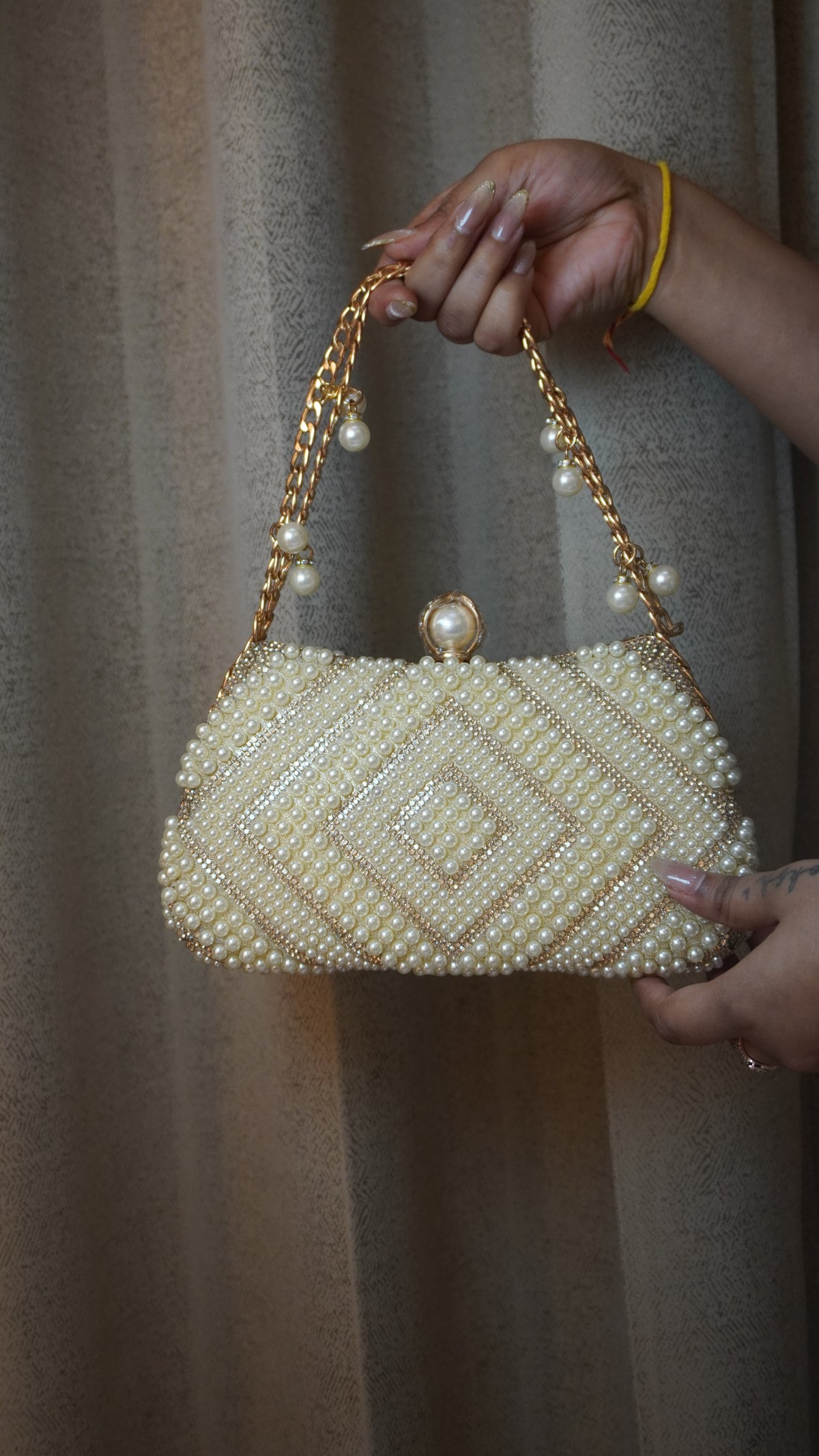 Pearl beaded clutch with diamond-pattern detailing and golden-toned chain handle