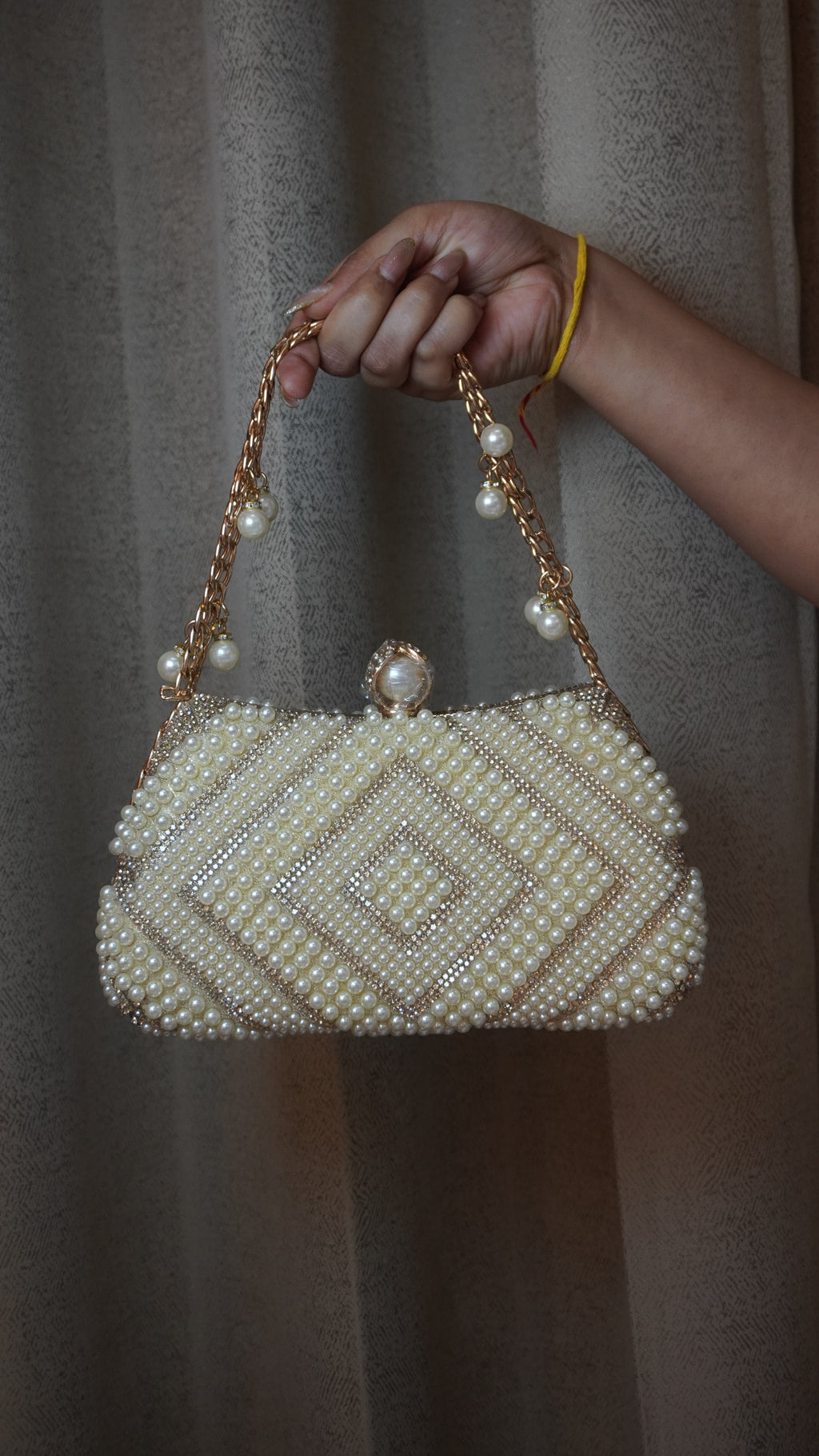 Pearl beaded clutch front view with pearl-style clasp and chain charms