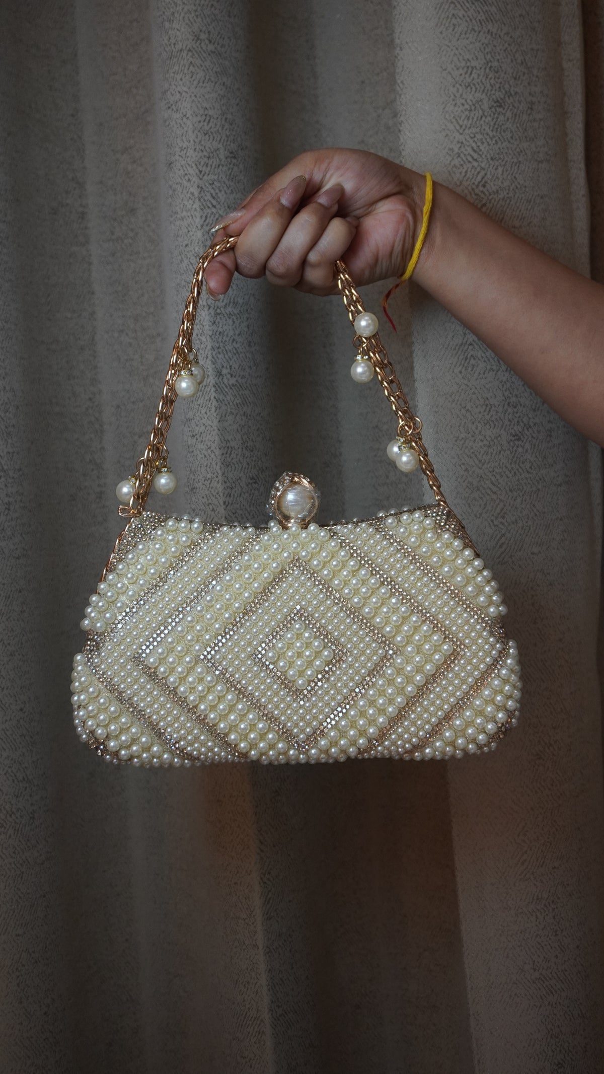 Pearl beaded clutch front view with pearl-style clasp and chain charms
