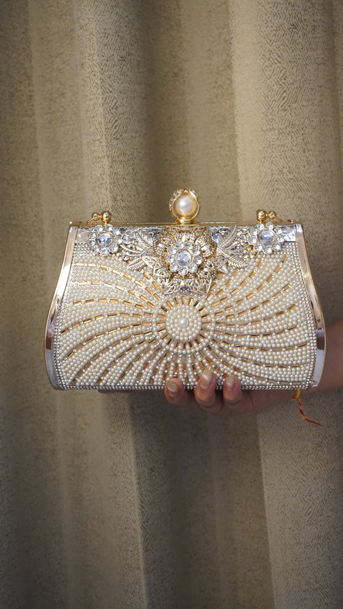 Brass clutch with radiating pearl beadwork and geometric decorative accents