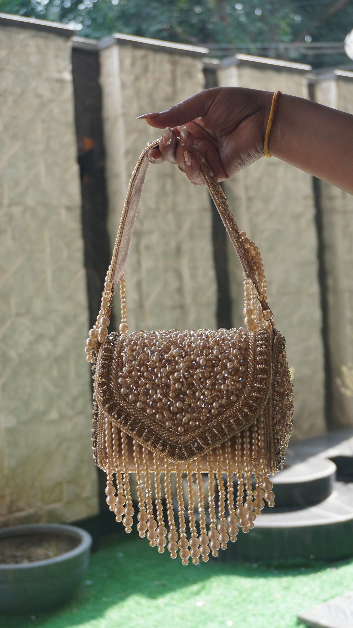 Rose-gold beaded clutch with embroidered handle, reverse view