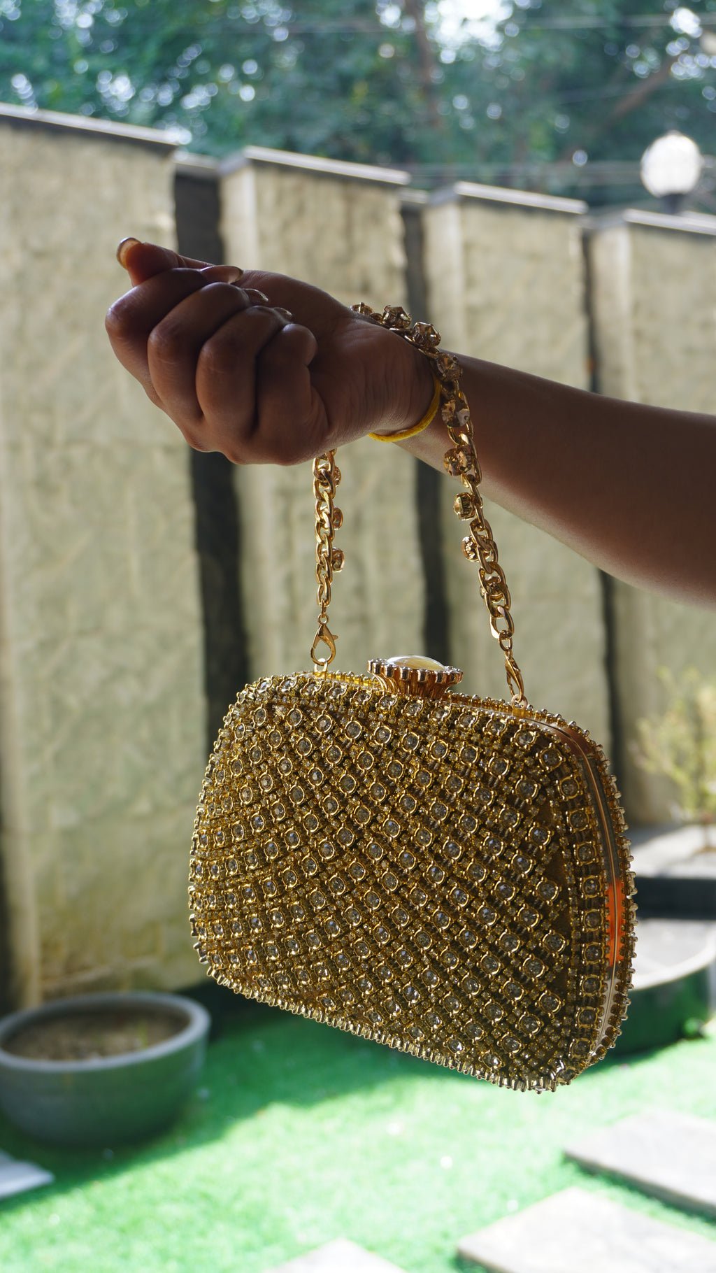 Golden bridal clutch with dense crystal work and decorative top clasp