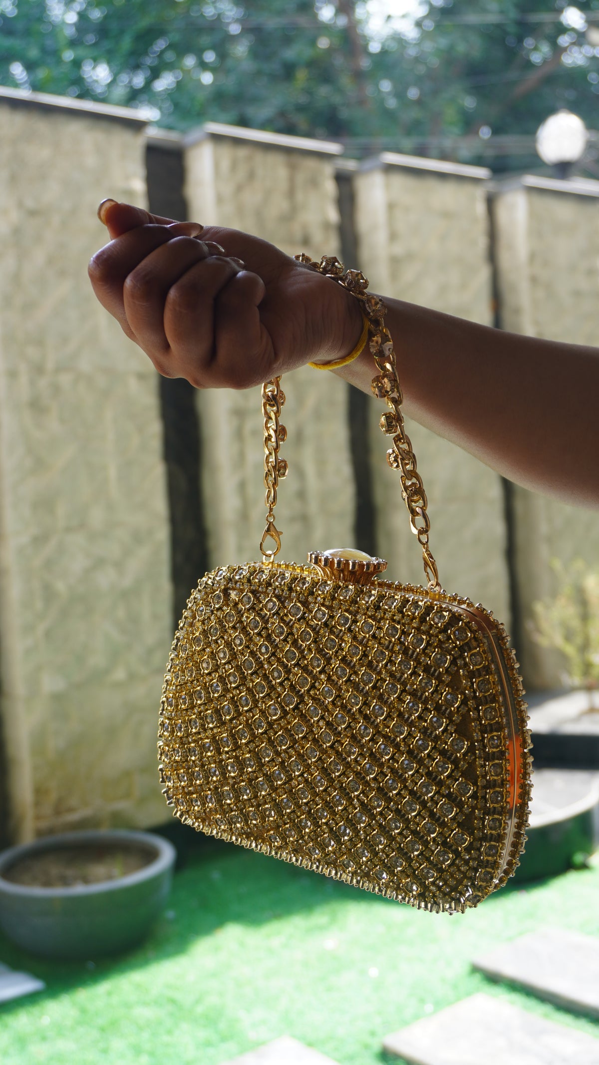 Golden bridal clutch with dense crystal work and decorative top clasp