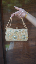 Golden flower-embroidered clutch with floral embellishments and chain carry handle
