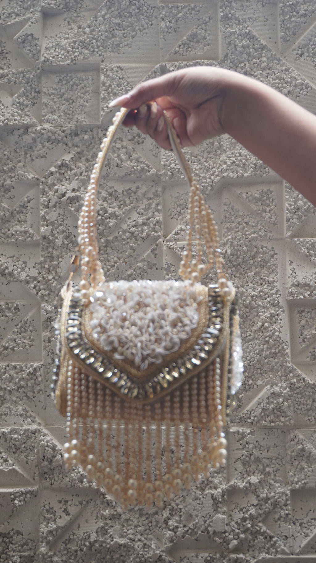Side view of golden beaded handbag with floral detailing and sparkling trim