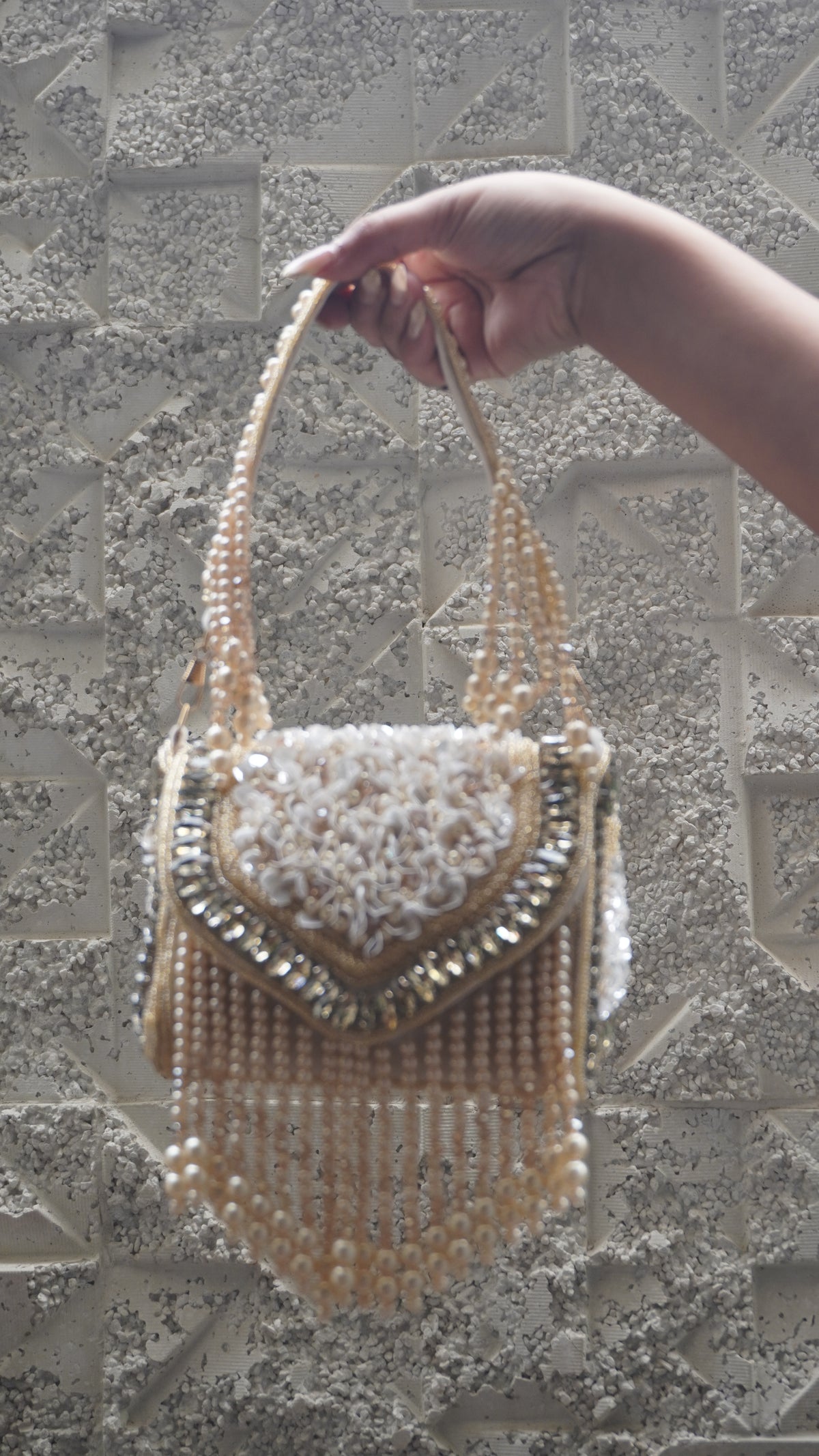 Side view of golden beaded handbag with floral detailing and sparkling trim