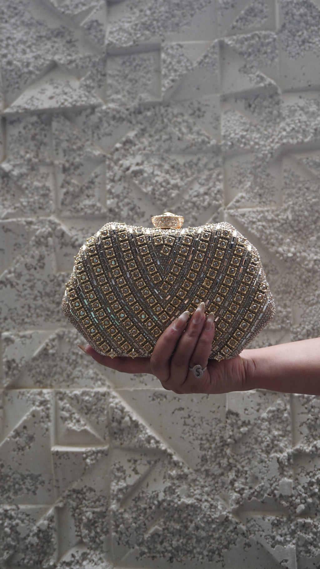 Reverse of golden party clutch with geometric embellishments and top clasp