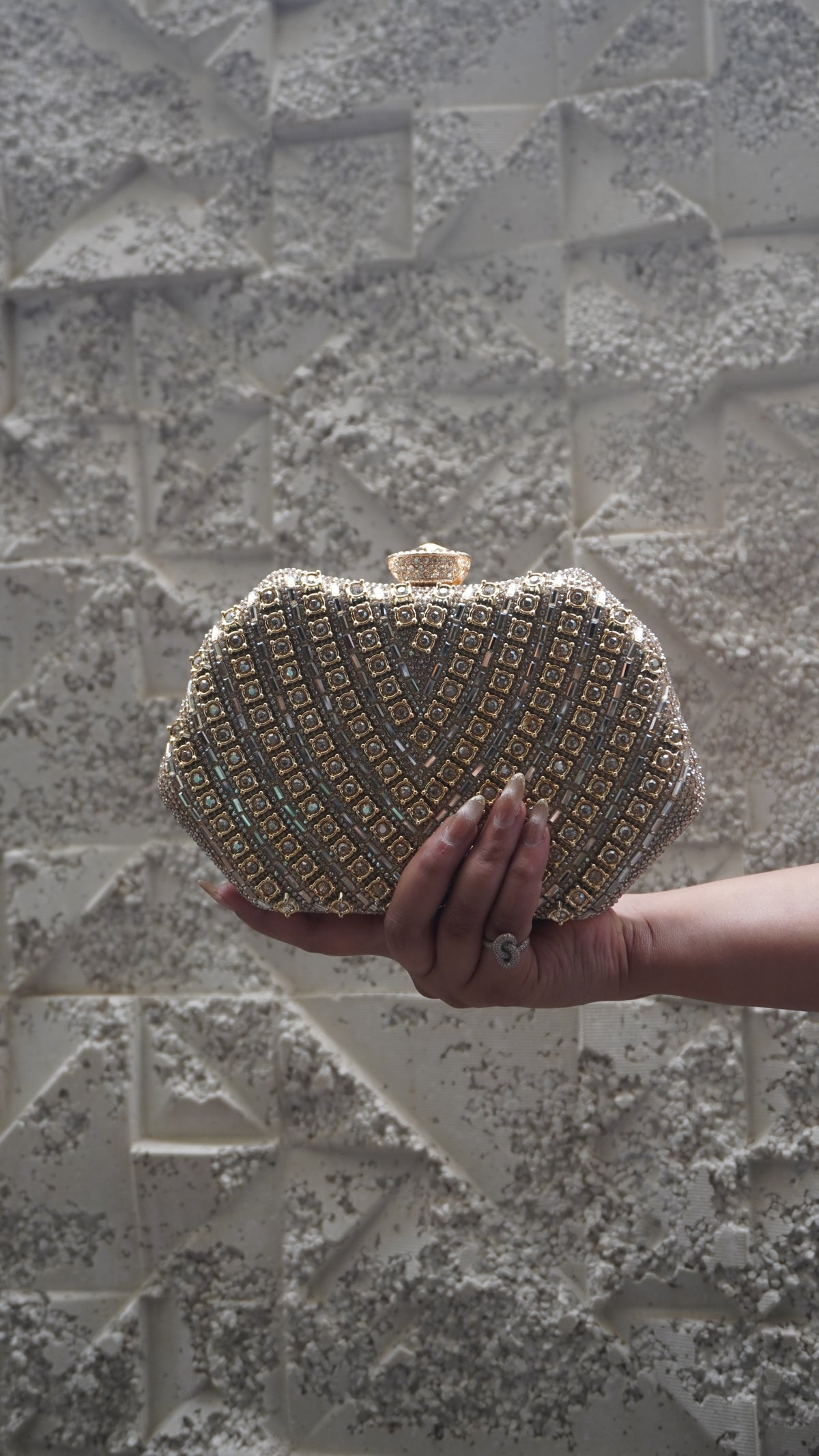 Reverse of golden party clutch with geometric embellishments and top clasp
