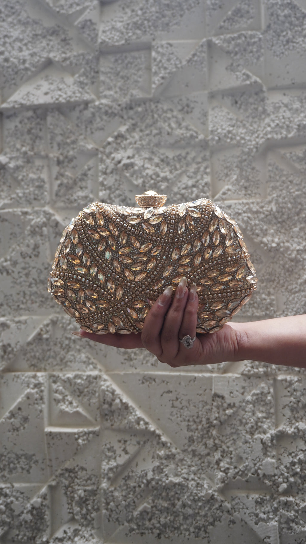 Golden party clutch with leaf-shaped sparkling accents and all-over decorative work