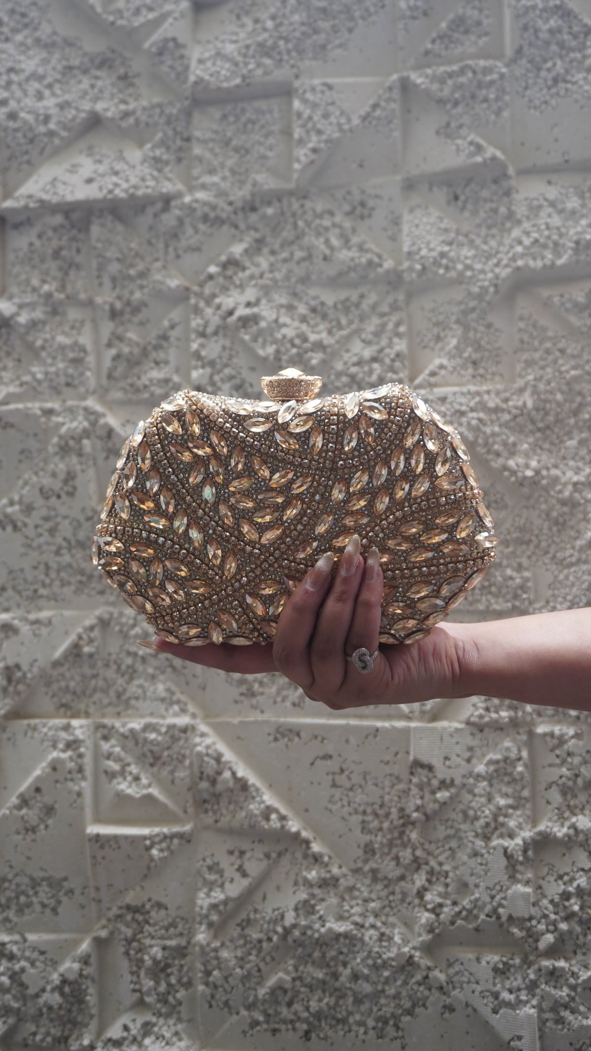 Golden party clutch with leaf-shaped sparkling accents and all-over decorative work