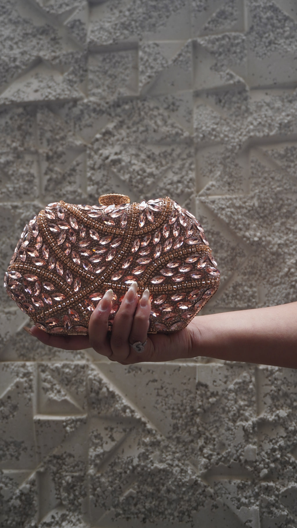 Pink party clutch with sparkling leaf-shaped accents and all-over decorative work