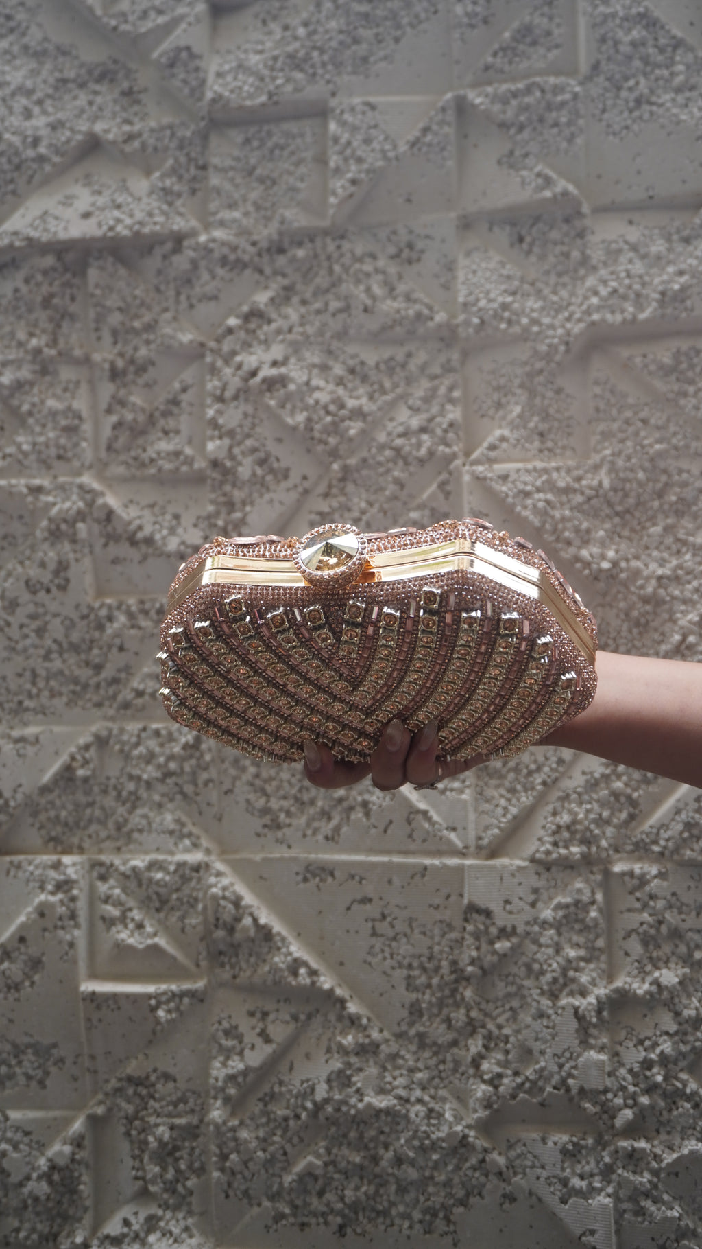 Pink party clutch showing geometric reverse embellishments and gold-toned top clasp