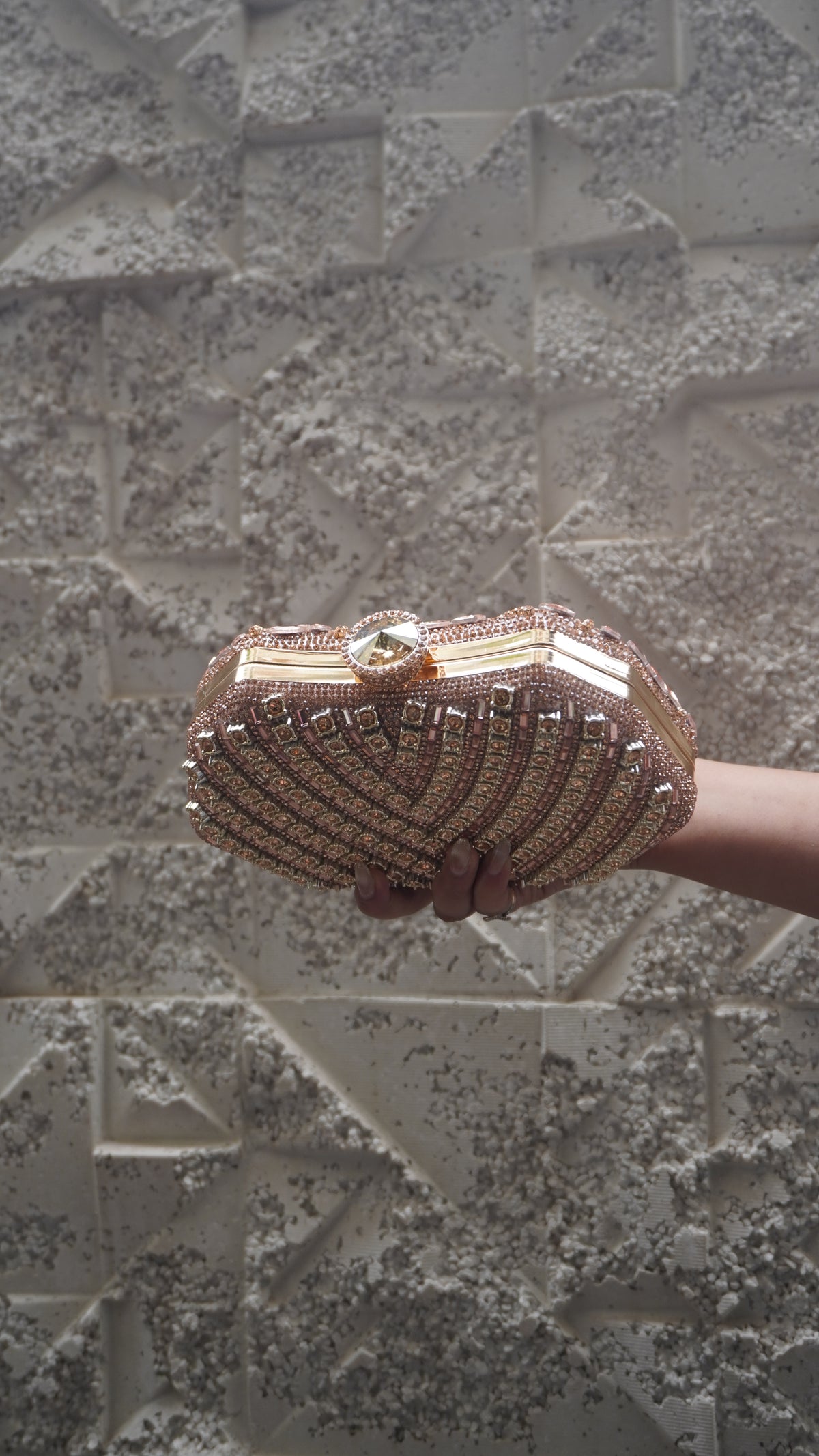 Pink party clutch showing geometric reverse embellishments and gold-toned top clasp