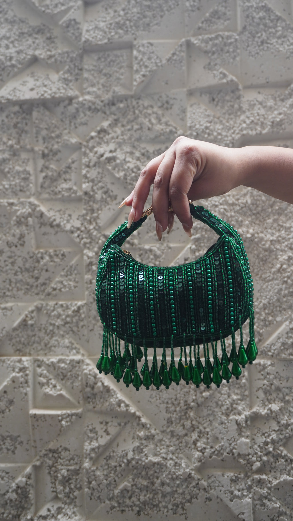 Emerald green small bag showing sequin and bead detailing with hanging teardrop fringe