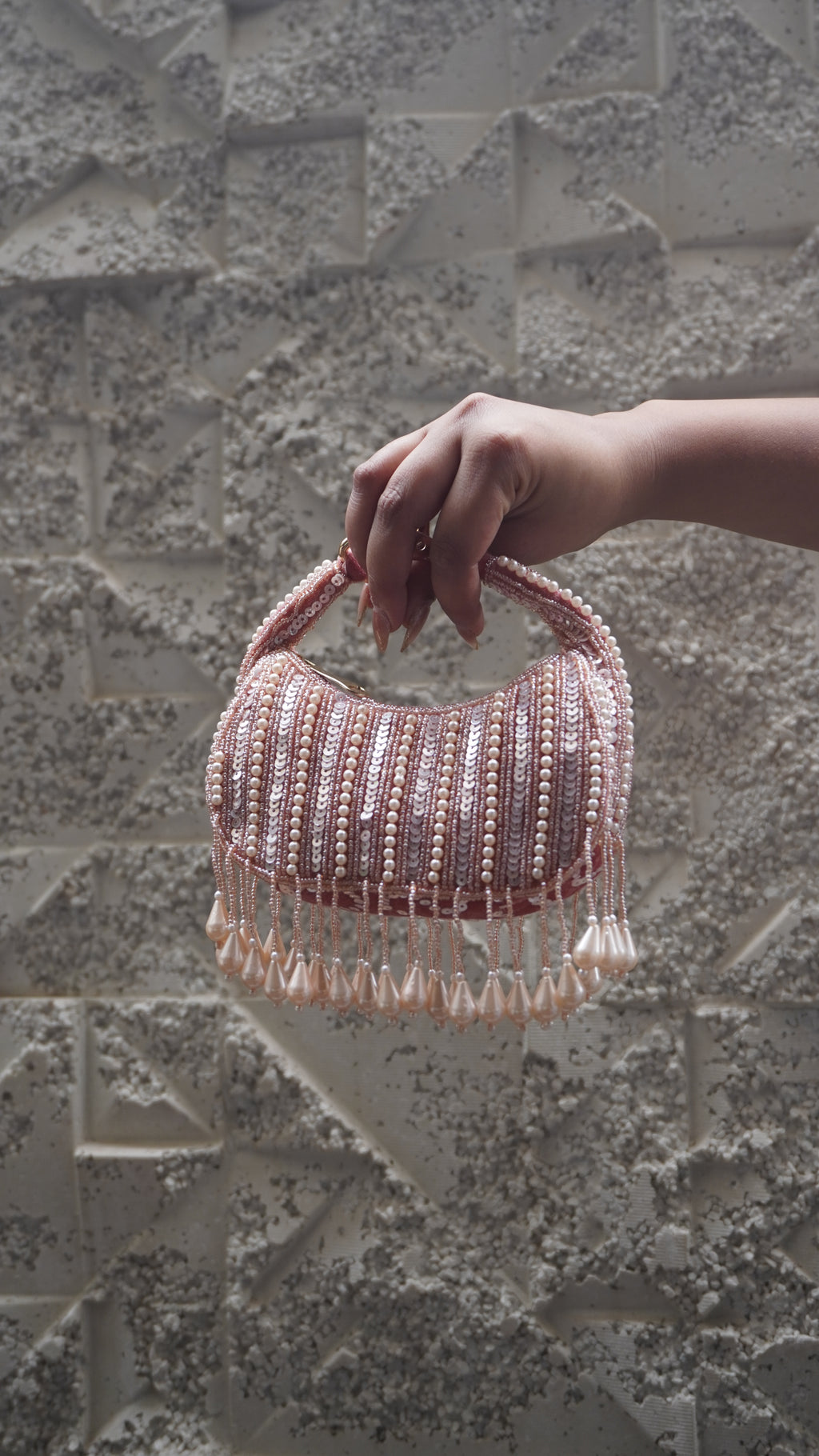 Pink small bag showing pale bead and sequin detailing and hanging teardrop fringe
