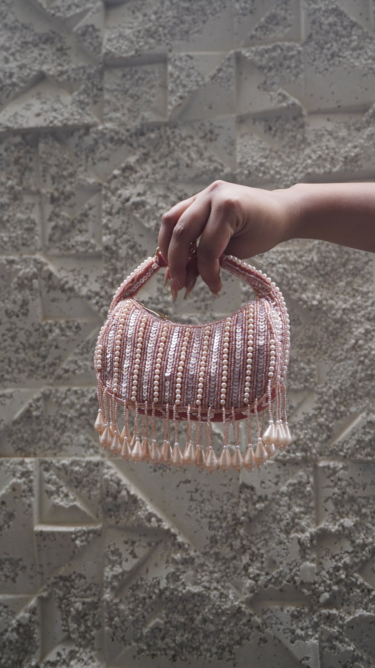 Pink small bag showing pale bead and sequin detailing and hanging teardrop fringe