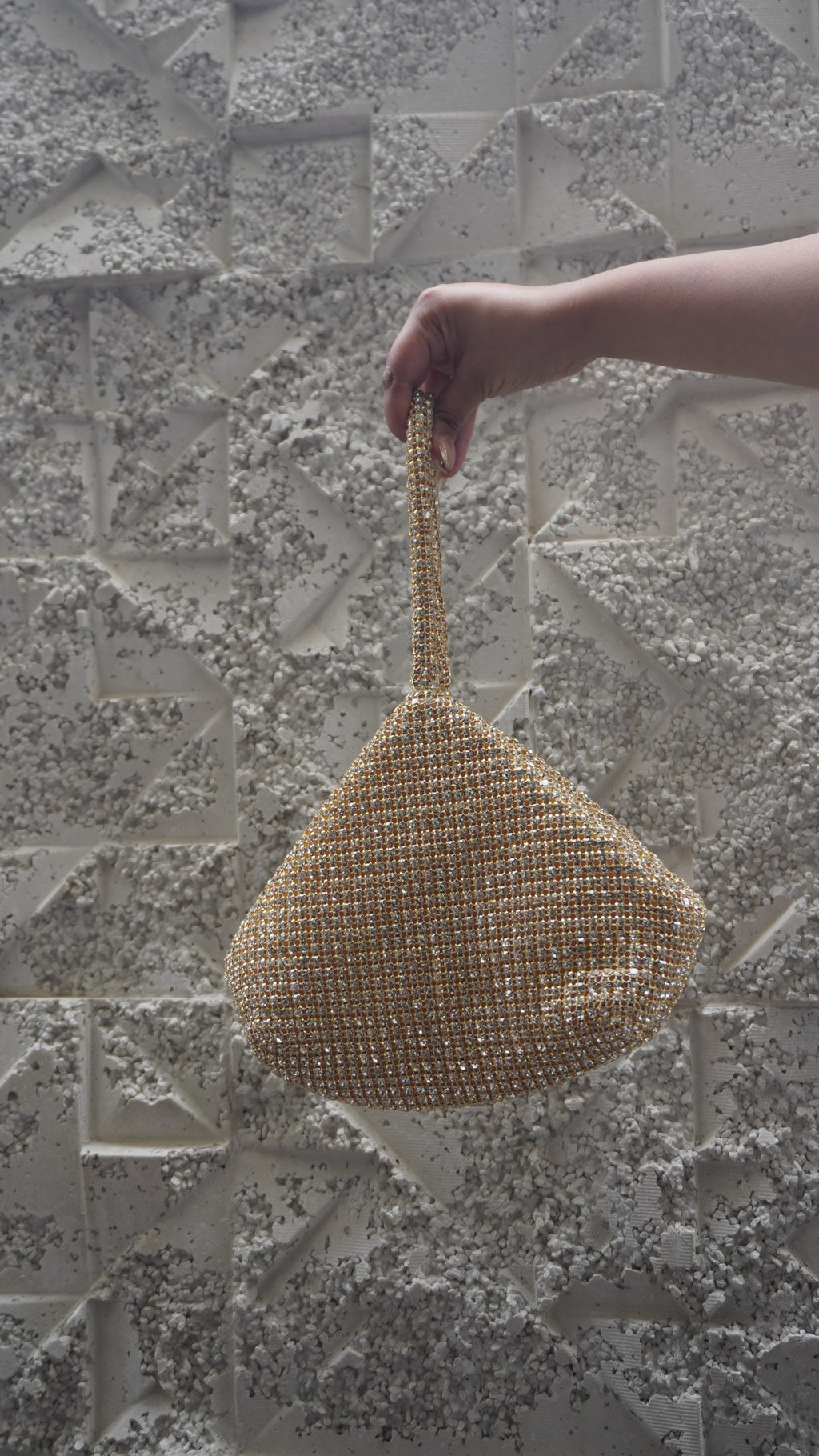 Full view of golden triangular beaded potli bag with rounded base