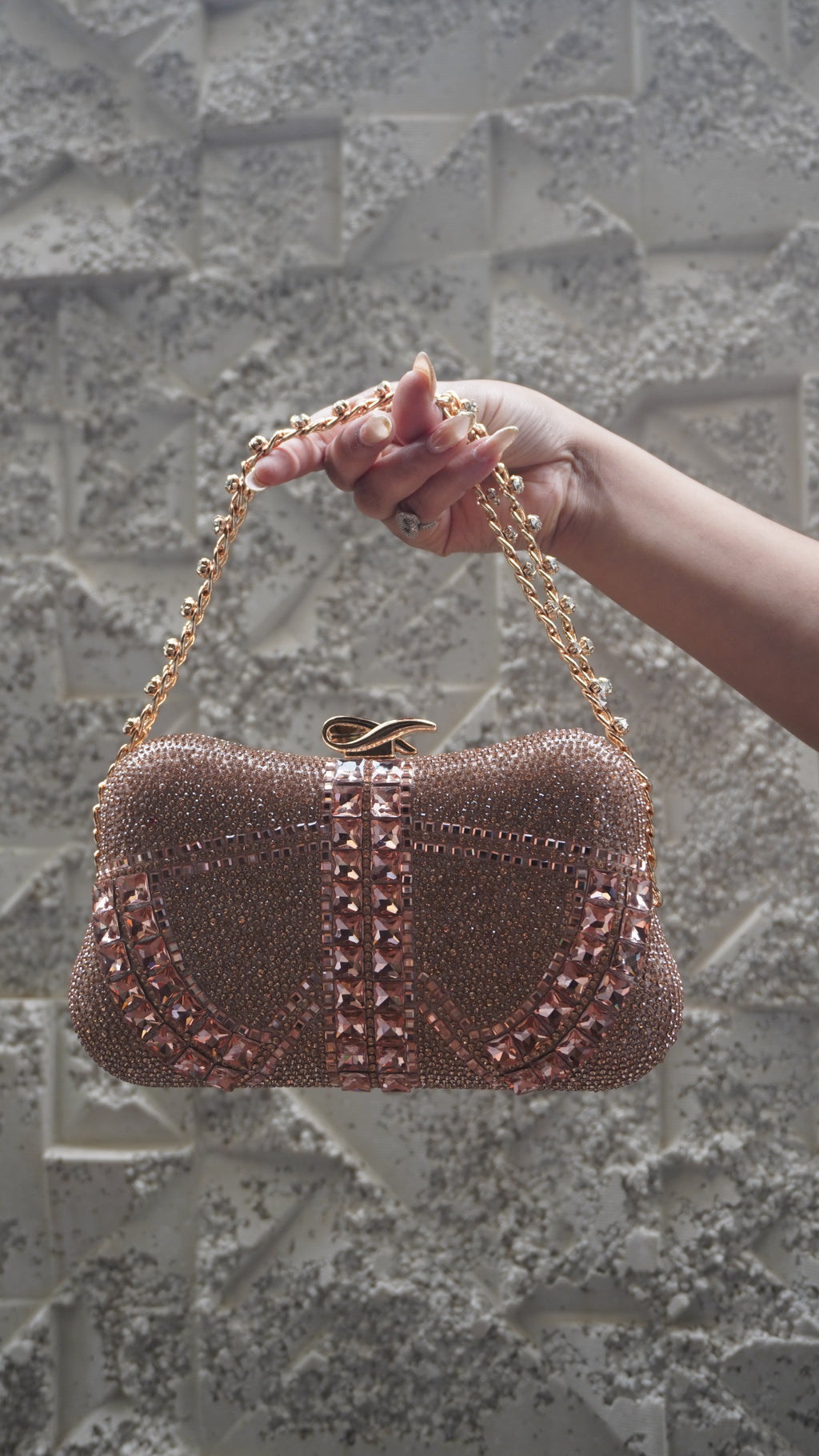 Rose pink clutch showing fine beadwork and curved patterns of faceted embellishments