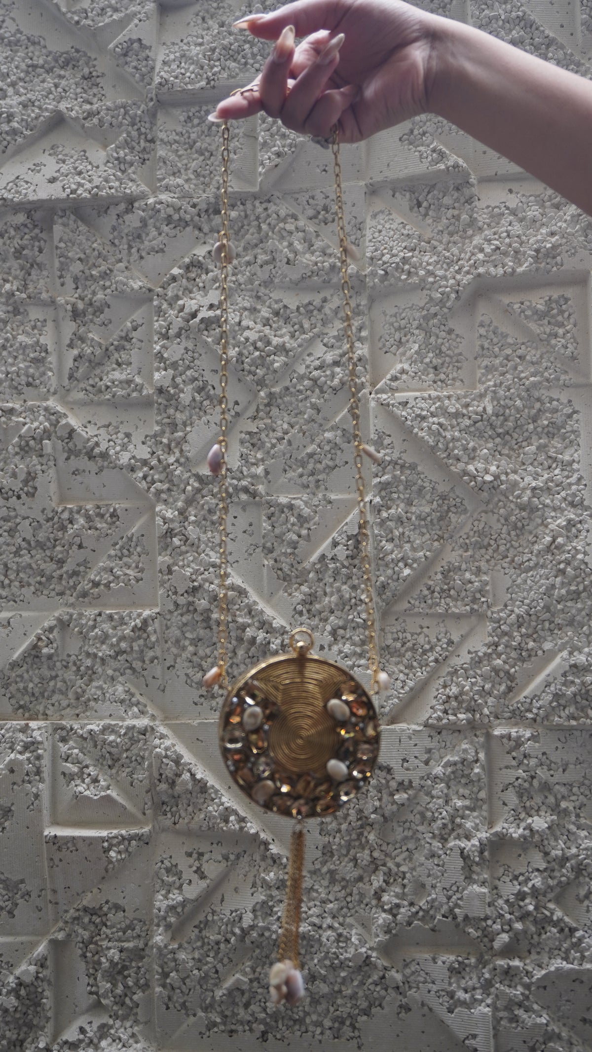 Golden brass round embellished sling bag with long chain strap and hanging tassel
