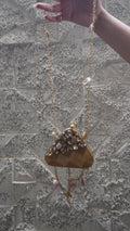 Golden brass triangular embellished sling bag with hanging charms
