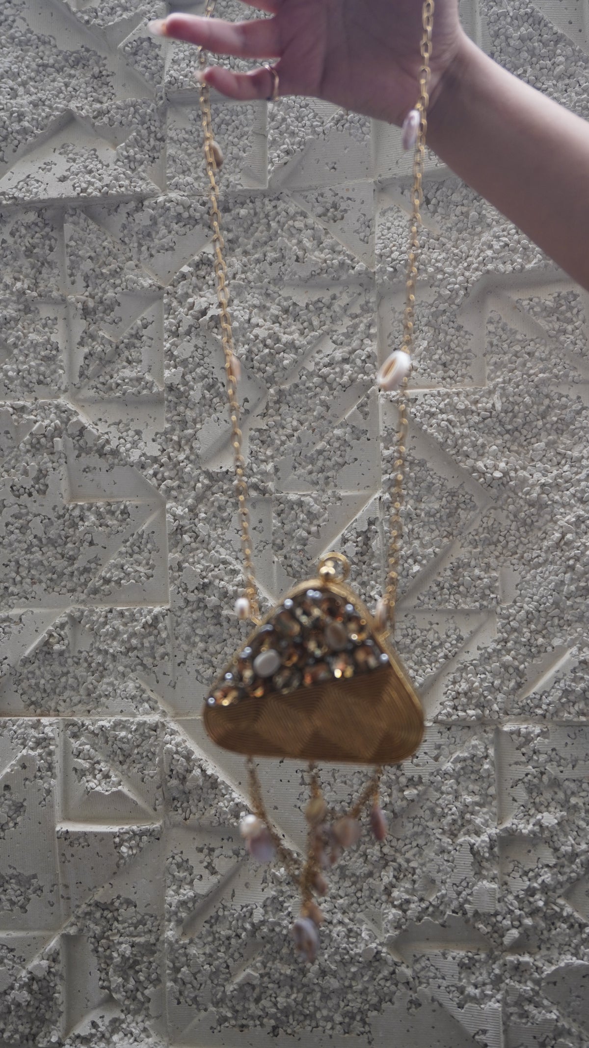 Golden brass triangular embellished sling bag with hanging charms